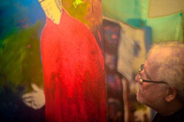 istock Elderly man with white hair, artist, painter, working.. 636918106