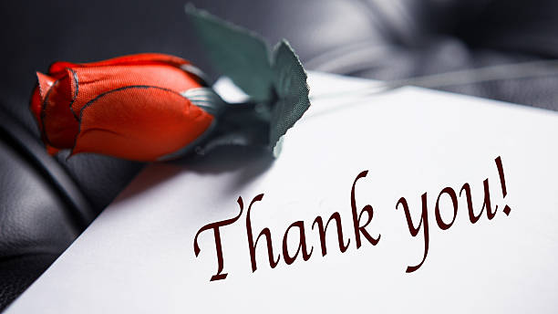 istock Thank You written on paper next to red rose 636922968