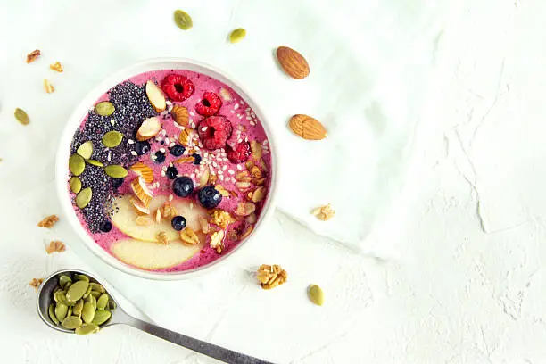 Smoothie bowl with fresh berries, nuts, seeds and homemade granola for healthy breakfast, copy space