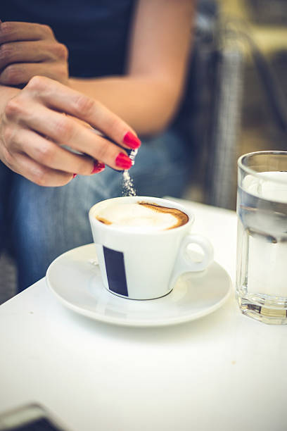 istock Female hand pours sugar into coffee 636923860