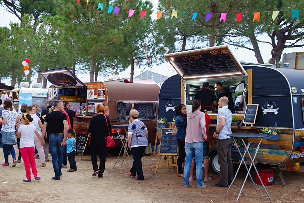 Food trucks in a local festival Cambrils, Spain - June 4, 2016: People with their families around a local festival with different food trucks, in the summer location for holidays of Cambrils, in the Gold Coast of Catalonia, Spain cambrils stock pictures, royalty-free photos & images