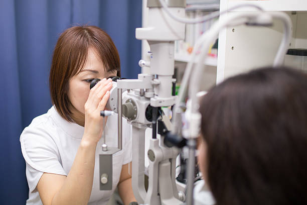 Female doctor inspecting patient's eye stock photo