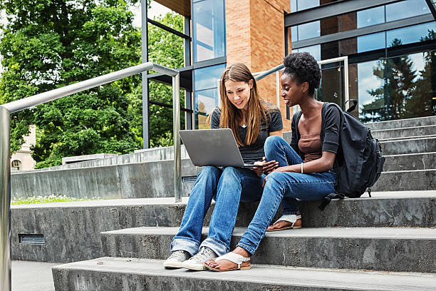 due studentesse universitarie nel campus con laptop - university student laptop campus foto e immagini stock