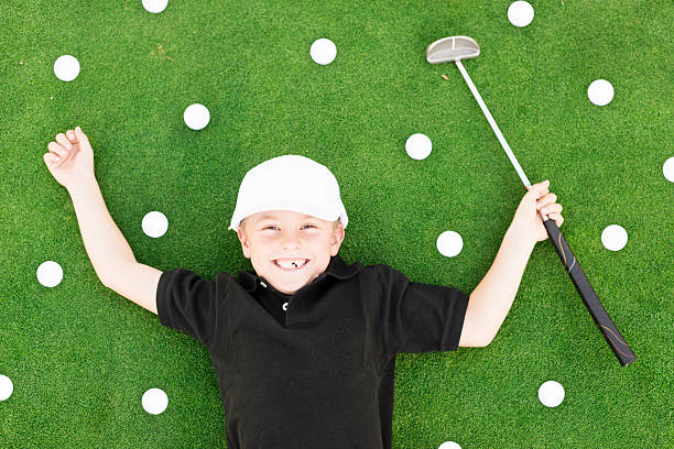 Jeune garçon s’amusant sur le terrain de golf - Photo