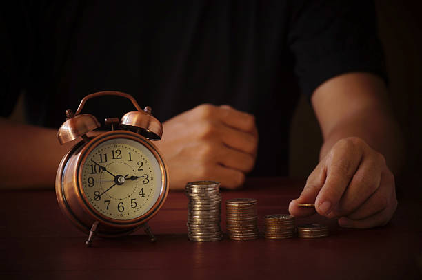 istock hand  put money on pile of coin on table 636938086