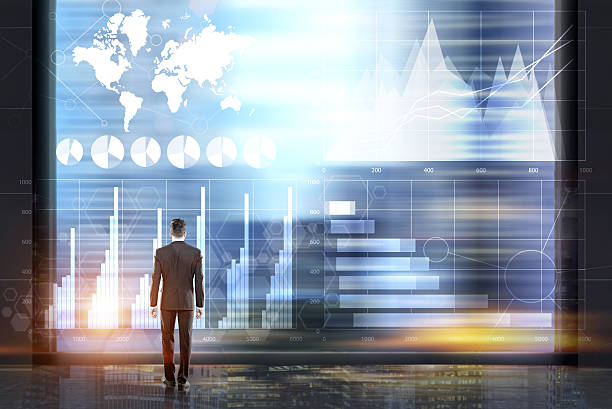 istock Man in a room with blue holographic diagrams 636940882