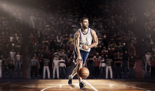 istock basketball player in light on professional court with ball 636943326
