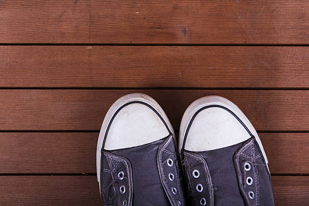 istock Old canvas shoes on a wooden floor 636946580