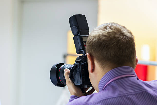 istock Bend young man taking photo with digital camera side view. 636947190
