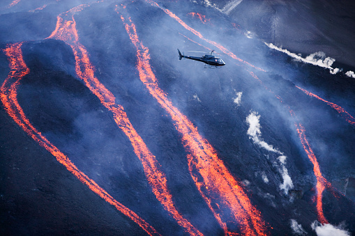 Helicopter with turists flying over the lavafalls at Fimvorduhals.  The initial March 21 2010 eruption created a 2,000-foot-long (500-meter-long) fissure in Fimmvorduhals Pass, to the west of the volcano's summit.