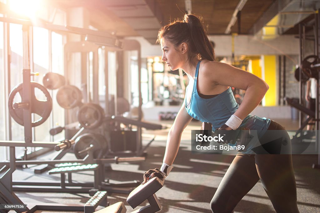 Sportive fille soulevant des poids dans la salle de gym. - Photo de Femmes libre de droits