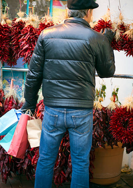 weihnachtsshopping: mann mit bunten taschen mit kranz - wreath chili pepper pepper ristra stock-fotos und bilder