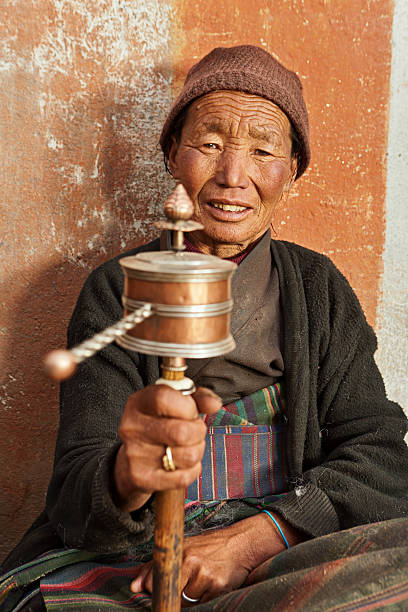 istock Tibetan woman holding praying wheel, Upper Mustang 636948792