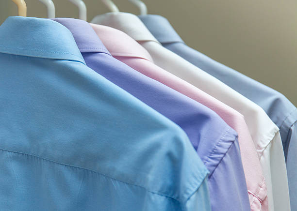 istock bright men's shirts hanging on hangers  gray background 636949342