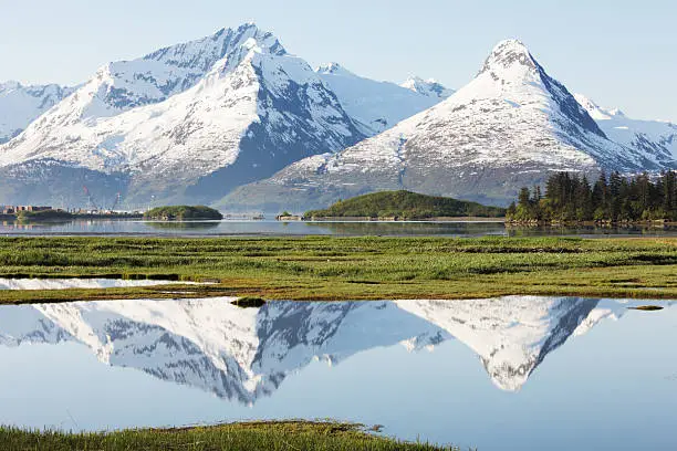 Chugach Mountains surrounding Valdez, Alaska reflect in foreground ponds inside Prince William Sound.