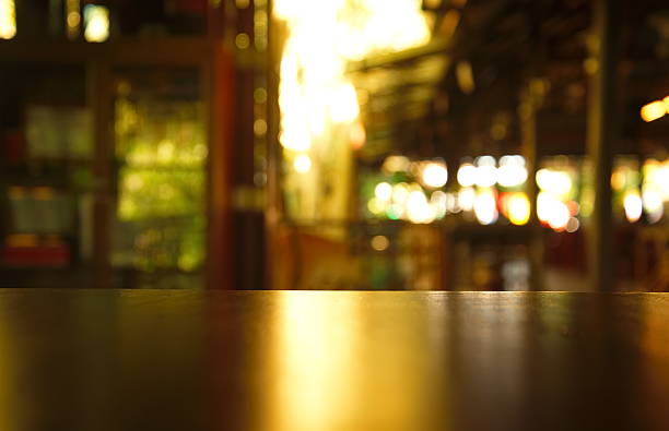 istock top wood table with blur bokeh light bar cafe background 636955464