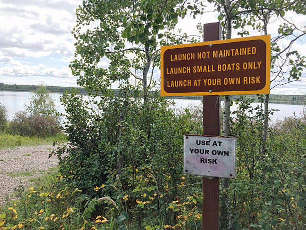 istock Small Unmaintained Boat Launch with Warning Signs 636958004