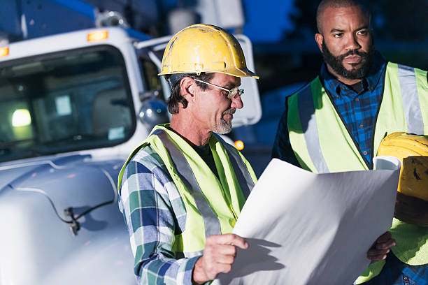 istock Two workmen in safety vests with truck 636961678