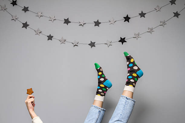 Women's legs in funny socks on a gray background.