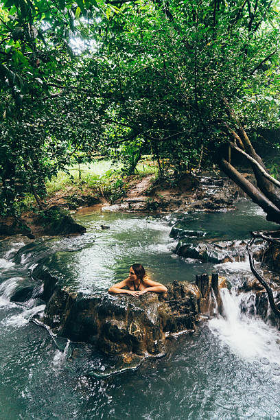 istock Woman bathing in hot spring waterfall 636966462