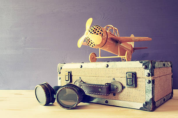 istock vintage toy plane and old suitcase next to pilot glasses 636968234
