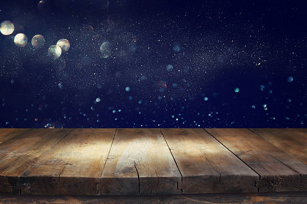 istock old wooden table in front of glitter lights background 636968614