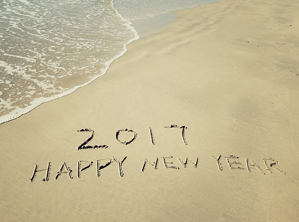 istock happy new year 2017 message on the sand beach 636970072