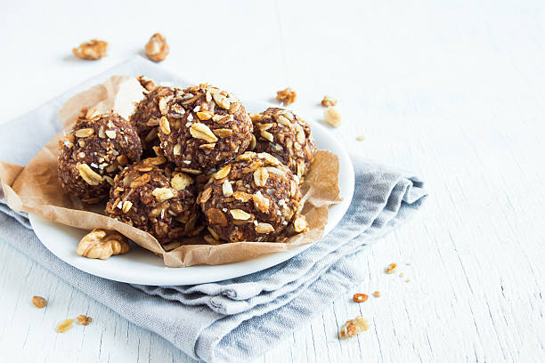 energy granola bites Healthy organic energy granola bites with nuts, cacao, banana and honey - vegan vegetarian raw snack or meal biting stock pictures, royalty-free photos & images