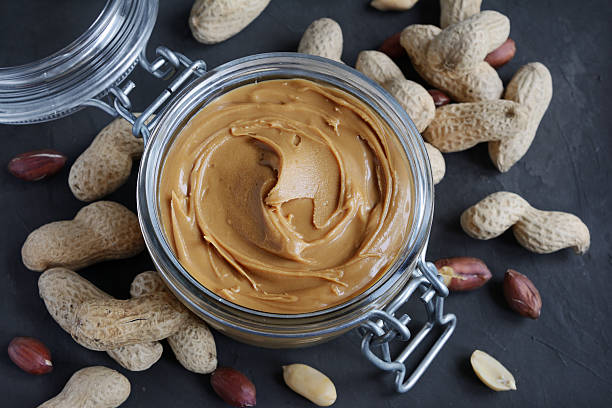istock Peanut butter in a glass jar and peanuts 636971736