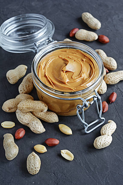 istock Peanut butter in a glass jar and peanuts 636971796