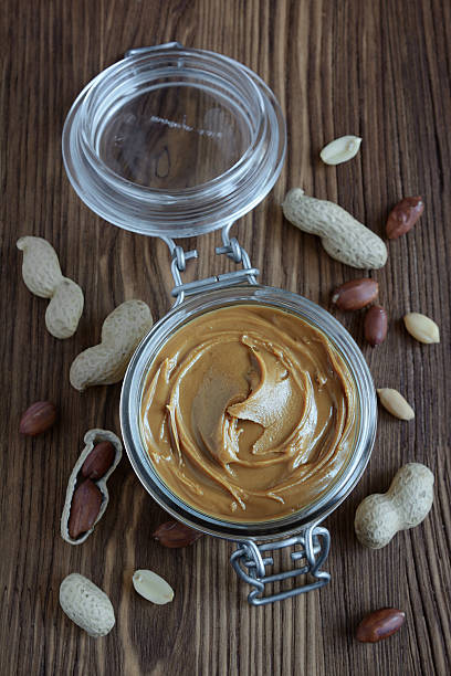 istock Peanut butter in a glass jar and peanuts 636971846