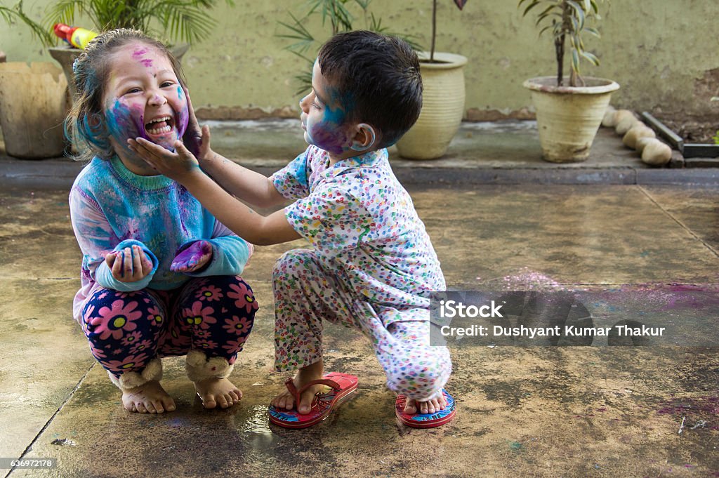 Kids Celebrating Holi Festival of Colors Two Indian kids with their face smeared with colors celebrate Holi, the festival of colors. Child Stock Photo