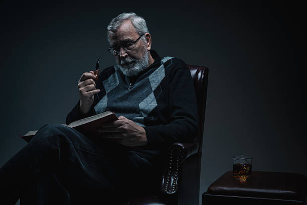 Glass of whiskey with smoking cigar on dark wooden table