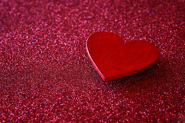 istock Wooden red hearts on red shiny background 636976172