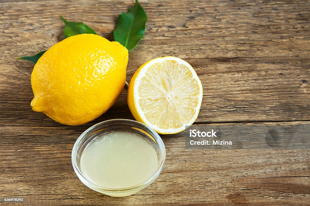 Fresh lemon juice Fresh lemon juice in small bowl and lemons over rustic wooden background with copy space - healthy ingredient for cooking and baking Backgrounds Stock Photo