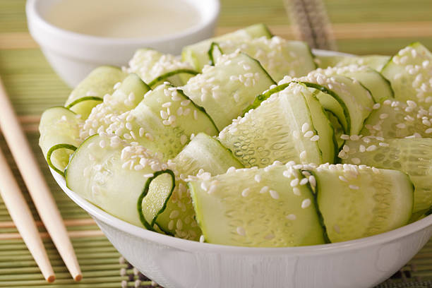 Japanese salad with fresh cucumber and sesame seeds close up Japanese sunomono salad with fresh cucumber and sesame seeds close up in a bowl. horizontal sunomono stock pictures, royalty-free photos & images