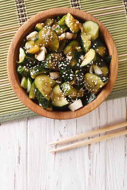 istock Chinese cucumber salad with sesame seeds closeup. Vertical top view 636979896