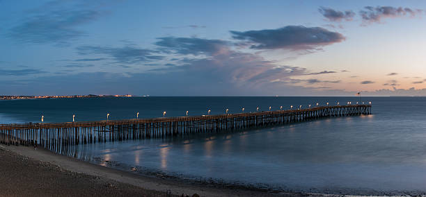 istock Glowing lamps line the pier at sunset. 636980964