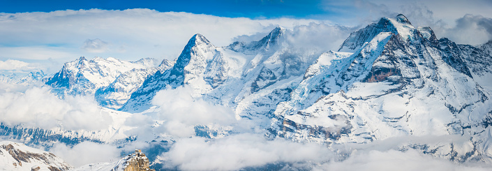 The cable car station on Birg (2684m) on its dramatic rocky summit location overlooked by the iconic north face of the Eiger (3970m) and Jungfrau (4158m) high in the Alps, Switzerland.