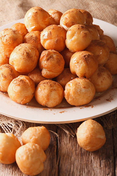 istock Homemade fried donuts loukoumades with cinnamon closeup. vertical 636982284