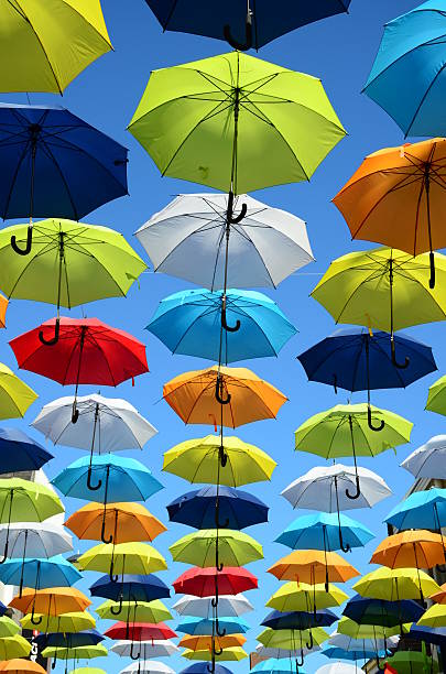 colorido fondo de paraguas. paraguas de colores en el cielo soleado. decoración de calles. - rainbow umbrella descriptive color multi colored fotografías e imágenes de stock