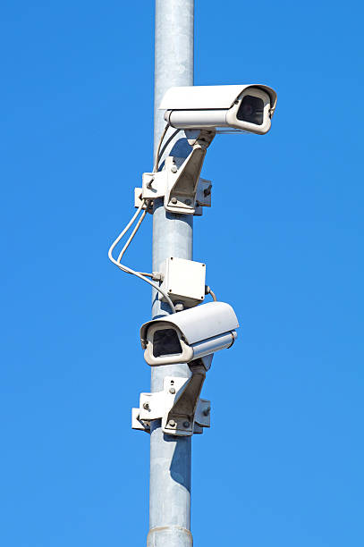 istock Surveillance cameras against blue sky Security Cctv 636984414