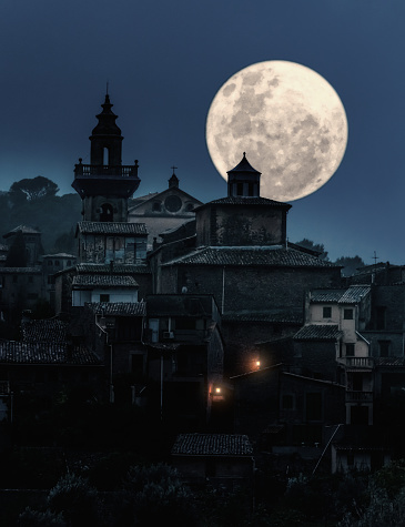 full moon over medieval village at night