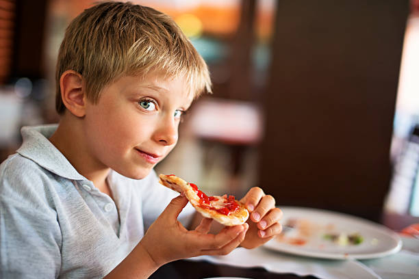 istock Little boy enjoying pizza lunch 636987444