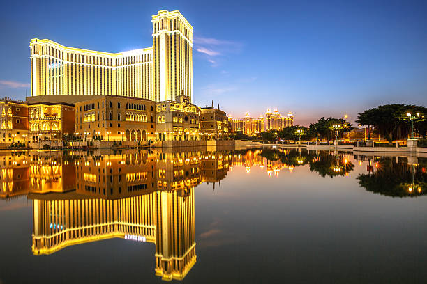 Macau, China - December 8, 2016: golden light illumination of The Venetian Macau mirroring on lake at twilight, the largest casino in the world and the largest single structure hotel building in Asia.