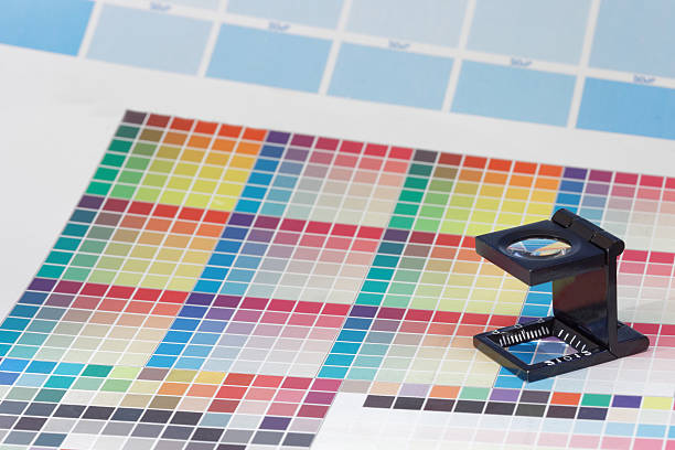 istock Magnifier or printer's loupe on a colorful CMYK test sheet 636991814