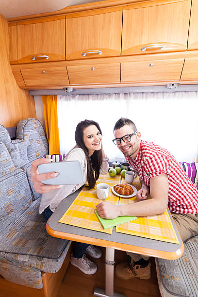 istock Cheerful young couple eating and making selfie in camper 636992930