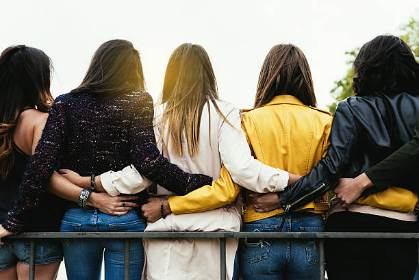 Group of happy friends hugging in the street.