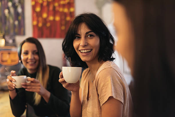 istock Three beautiful women drinking coffee and chatting. 636996944