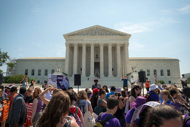 Abortion-rights supporters outside US Supreme Court Washington DC, USA - June 27, 2016: Pro-choice supporters stand in front of the U.S. Supreme Court after the court, in a 5-3 ruling in the case Whole Woman's Health v. Hellerstedt, struck down a Texas abortion access law. reproductive rights stock pictures, royalty-free photos & images